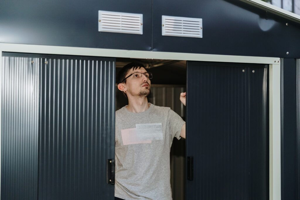 Technician installing a new garage door while explaining installation cost and project timeline