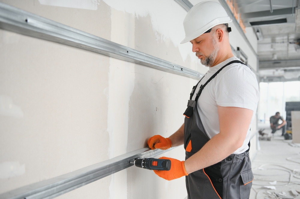 Professional garage door installation experts installing a new residential garage door safely