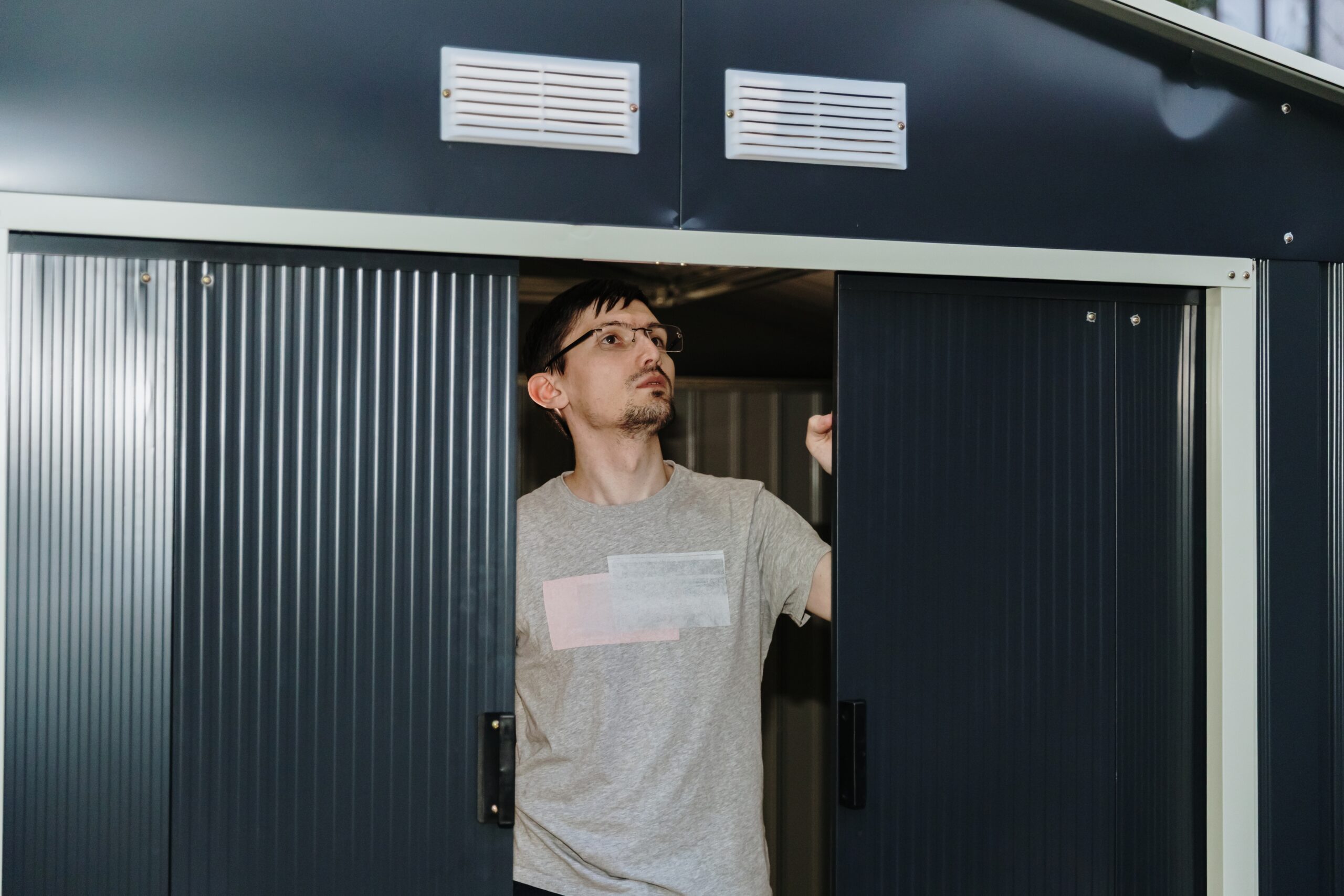 Technician installing a new garage door while explaining installation cost and project timeline