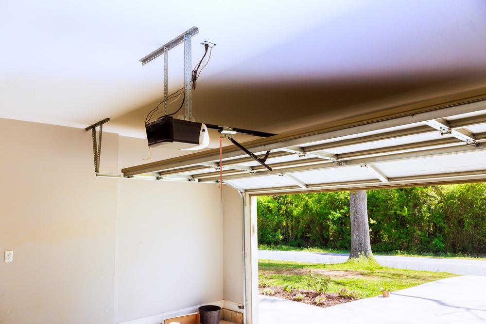 Technician inspecting an old garage door opener that needs replacement