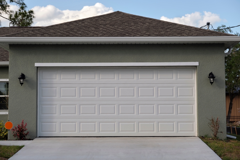 Homeowner checking how to balance a garage door after DIY repair and maintenance work