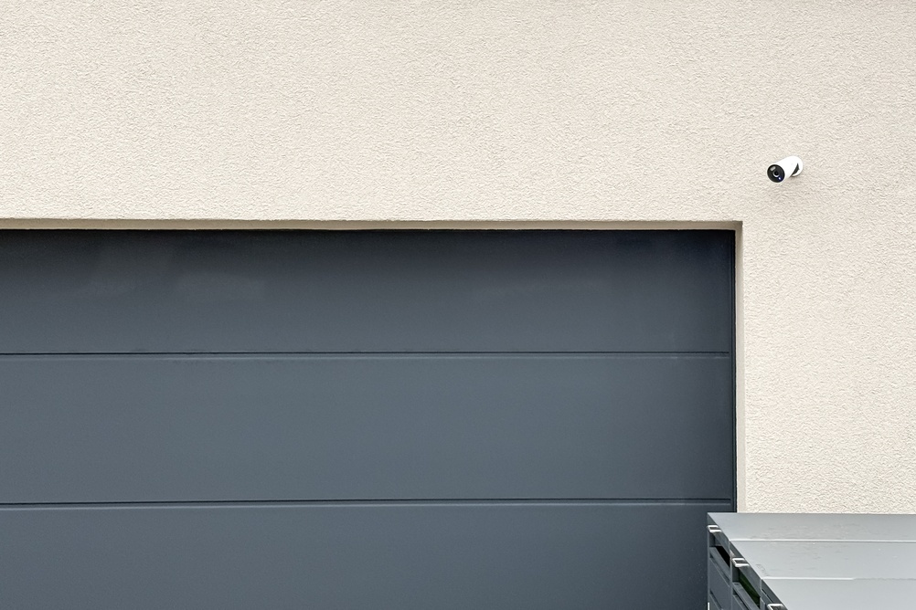 Modern garage opener with an integrated 4K camera monitoring package deliveries at a home's garage
