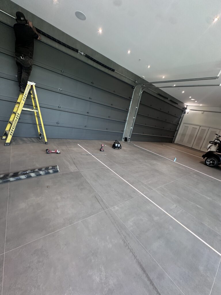 Home recording studio owner installing materials to soundproof garage door for improved audio isolation
