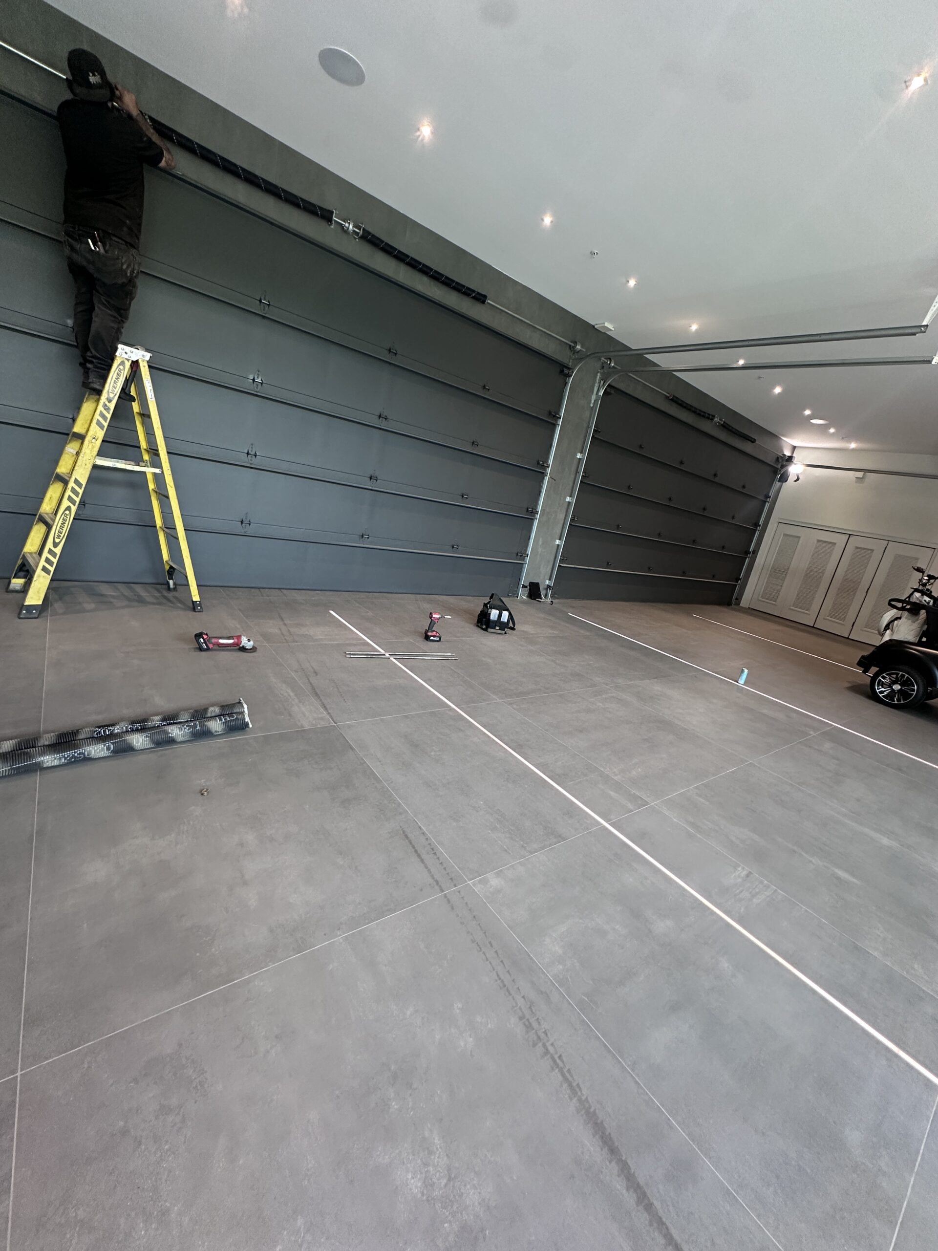 Home recording studio owner installing materials to soundproof garage door for improved audio isolation
